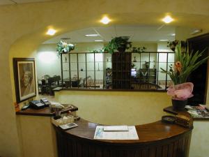 a waiting room with a reception desk and a mirror at Hotel Sassacci in Civita Castellana
