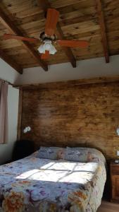 1 dormitorio con 1 cama con techo de madera en Septimo Sol en Capilla del Monte