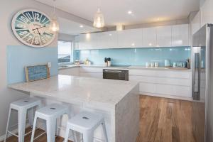 a kitchen with a large counter and a clock on the wall at Busselton Beach House in Busselton