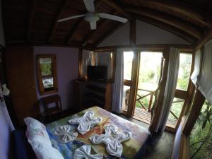 a bedroom with a bed in a room with windows at Cabañas Manamar in Villa Gesell