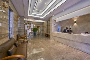 a lobby with two men sitting at a bar at Dubai Hotel in Gwangju