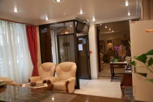 a living room with two chairs and a table at Hôtel des Pyrénées - Entre Bastille et Nation in Paris