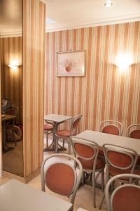 a dining room with tables and chairs and a painting on the wall at Hôtel des Pyrénées - Entre Bastille et Nation in Paris