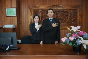 a man and a woman standing in front of a desk at Gerbera hotel in Puncak