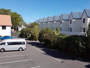 een wit busje geparkeerd op een parkeerplaats bij Bella Vista Motel & Apartments Christchurch in Christchurch