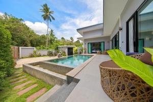 a swimming pool in the backyard of a house at Baan Bua in Laem Sor