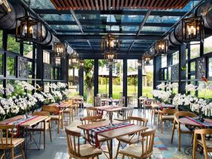 a large room filled with tables and chairs at RIMBA by AYANA Bali in Jimbaran