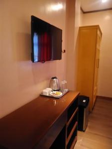 a hotel room with a television on the wall at Royal Mansion Hotel in Tabaco