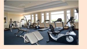a gym with several treadmills and exercise bikes at An Loc Hotel & Spa in Thanh Bình
