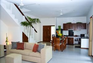a living room with a couch and a kitchen at Seminyak Villa Lumina in Seminyak