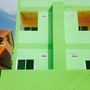 un edificio verde y blanco con ventanas. en J&E, en Nong Prue
