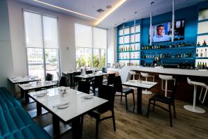 a restaurant with tables and chairs and a bar at Three-Bedroom Beachwalk Resort Apartment in Hallandale Beach