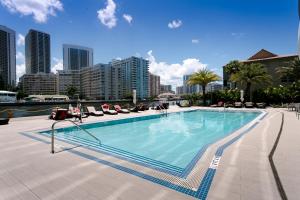 uma grande piscina com espreguiçadeiras e uma cidade em Three-Bedroom Beachwalk Resort Apartment em Hallandale Beach