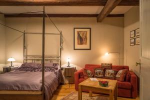 ein Schlafzimmer mit einem Bett und einem roten Sofa in der Unterkunft Alte Lateinschule in Quedlinburg