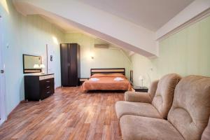 a bedroom with a bed and a couch in a room at Kontinent Hotel in Anapa