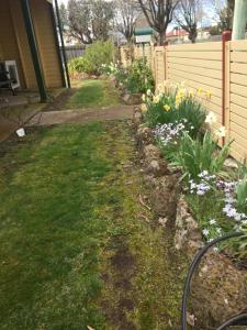 a garden with some flowers and a fence at Our Cottage in Ross