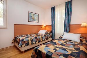 a hotel room with two beds and a window at Fontana Bayside Park in Jelsa