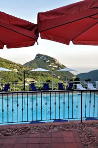 a pool with chairs and umbrellas on a resort at Villa Fernanda in Cava deʼ Tirreni