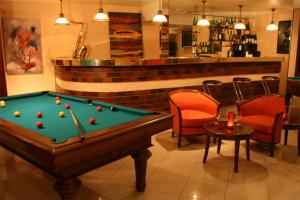 een pooltafel in een bar met stoelen en een bar bij Le Grand Monarque in Melun