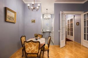 uma sala de jantar com uma mesa e cadeiras e um lustre em Engel Apartman em Budapeste