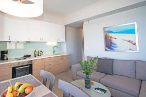 una cocina y una sala de estar con una mesa con un bol de fruta en Sonja Beachfront Apartments, en Kato Daratso