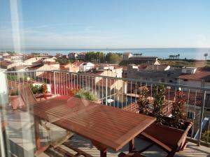 drewniany stół na balkonie z widokiem na miasto w obiekcie Sky Wellness Apartment w mieście Porto SantʼElpidio