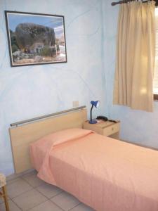 a bedroom with a bed and a picture on the wall at Rosa Hotel in Capoterra