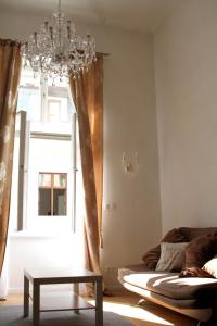 sala de estar con lámpara de araña, sofá y ventana en Paul's palace - absolute center!, en Bratislava