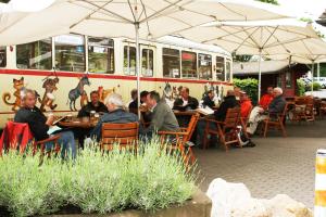 a group of people sitting at tables in front of a bus at AKZENT Hotel Stadt Bremen in Beverungen