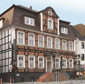 a brown and white building with white windows at AKZENT Hotel Stadt Bremen in Beverungen