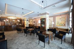 a restaurant with tables and chairs and a bar at Hotel Yaky Center in Piteşti
