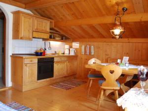 a kitchen with wooden cabinets and a table with chairs at Haus Südblick in Zell am See