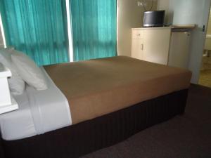 a bedroom with a large bed and a large window at Moondarra Motel in Innisfail