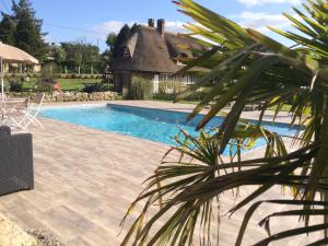 a house with a swimming pool in front of a house at La Régissière in Vatteville
