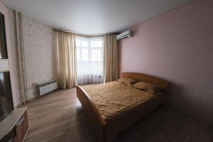 オレンブルクにあるApartment on Chkalova 51/1の小さなベッドルーム(ベッド1台、窓付)