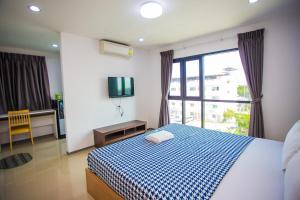 バンセーンにあるPromsook Apartmentのベッドルーム(青と白のベッド1台、窓付)