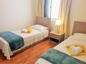 a bedroom with two beds and a lamp in it at 16 SANDY BEACH in Larnaca