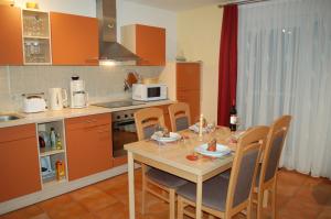 a kitchen with a table with chairs and a microwave at Zum Sonnenuntergang in Zingst
