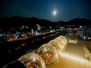 Trois dômes au-dessus d'un bâtiment la nuit dans l'établissement Aburaya Tousen, à Yamanouchi