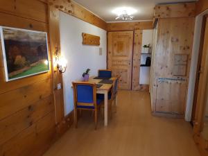 a dining room with a table and blue chairs at Appartement - Bristol Hôtel in Villars-sur-Ollon