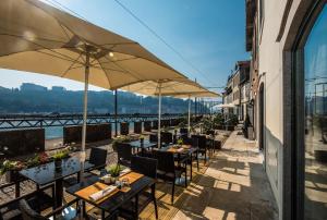 a patio area with tables, chairs and umbrellas at Vila Gale Porto Ribeira in Porto
