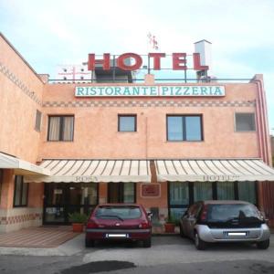 un hotel con dos coches estacionados frente a él en Rosa Hotel, en Capoterra