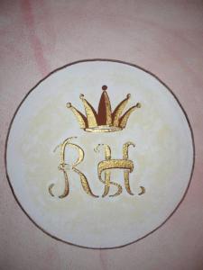 a plate with a crown on top of it at Rosa Hotel in Capoterra