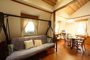 a living room with a couch and a table at Resort Garni CORU in Nagawa