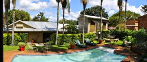 a backyard with a swimming pool and a house at Christie's Inn in Tzaneen