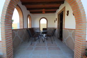 um pátio com uma mesa e cadeiras num edifício em Casa Melli em Conil de la Frontera