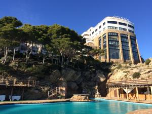 a building on a hill next to a swimming pool at Cap Sa Sal Turquesa in Begur