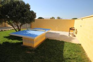 una mesa de ping pong en un patio junto a un edificio en Casa Melli en Conil de la Frontera