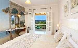 a bedroom with a bed and a desk and a window at Nefeli Hotel in Kommeno