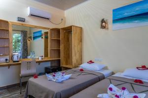 Habitación con 2 camas y escritorio. en Relax Residence Thoddoo Maldives, en Thoddoo